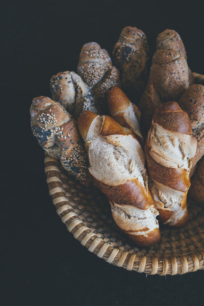 A top view of a basket filled with various freshly baked baguettes, perfect for food photography enthusiasts.